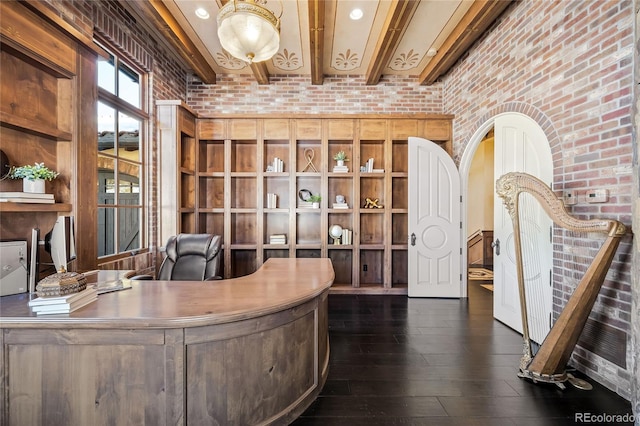 office featuring dark hardwood / wood-style flooring, brick wall, a towering ceiling, and beam ceiling