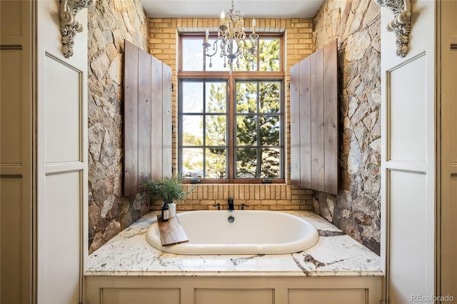 bathroom featuring an inviting chandelier and a tub