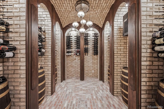 wine room featuring brick ceiling, brick wall, and vaulted ceiling