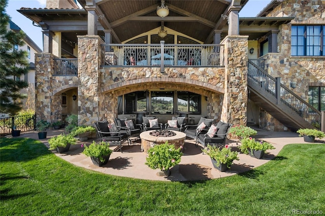 back of house with an outdoor living space with a fire pit and a patio