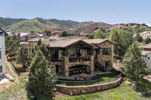 7188 Raphael Ln, Littleton, CO 80125 - back of property with a patio area, a tiled roof, a mountain view, and stairs
