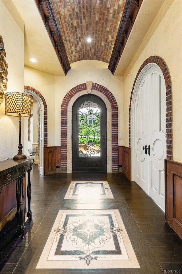 7188 Raphael Ln, Littleton, CO 80125 - entryway featuring brick ceiling, dark wood-style floors, arched walkways, lofted ceiling, and recessed lighting