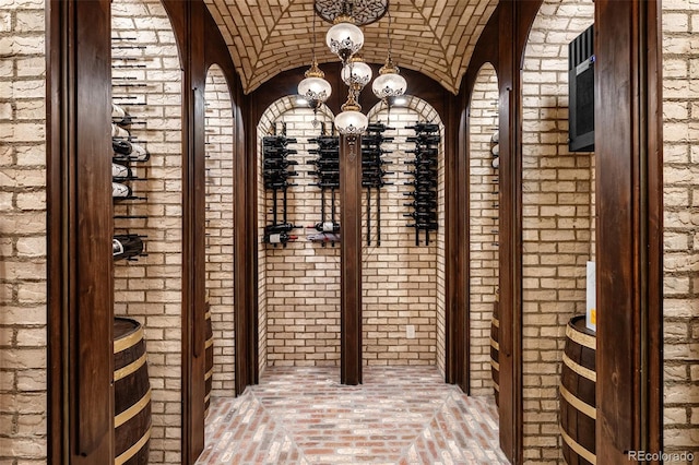 7188 Raphael Ln, Littleton, CO 80125 - wine area with brick floors, a chandelier, brick ceiling, lofted ceiling, and brick wall