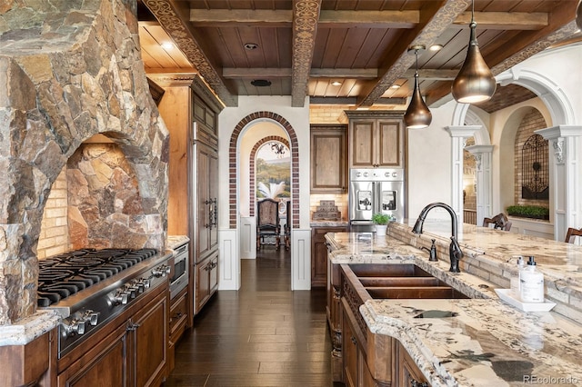 7188 Raphael Ln, Littleton, CO 80125 - kitchen with a sink, wood ceiling with exposed beams, appliances with stainless steel finishes, dark wood finished floors, and ornate columns