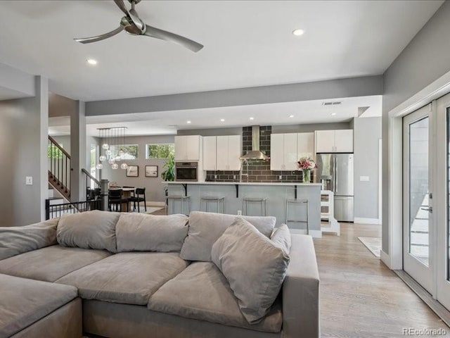 2508 S Pennsylvania St, Denver, CO 80210 - living area with a ceiling fan, stairs, light wood-type flooring, baseboards, and a chandelier
