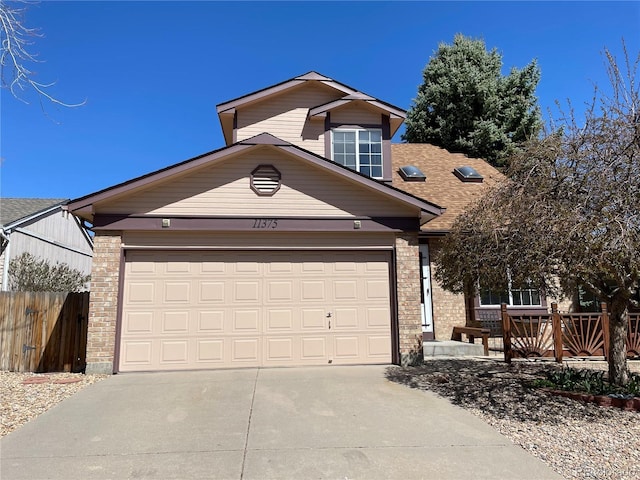 view of front of house with an attached garage, fence, and driveway