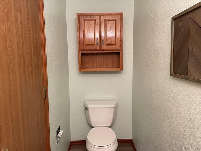 bathroom featuring toilet and baseboards