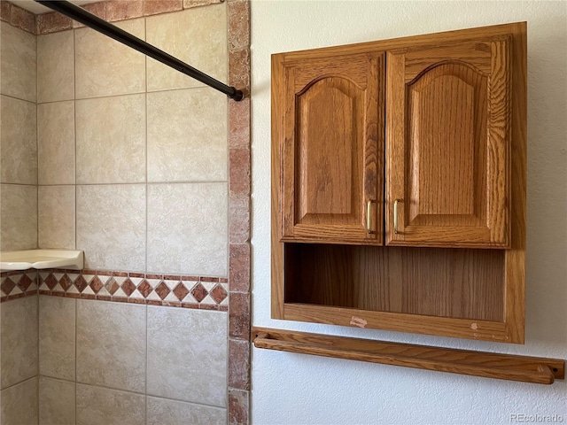 interior details featuring a tile shower