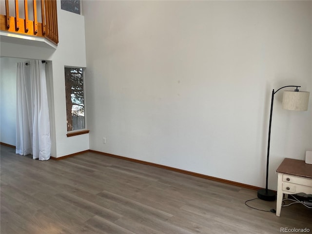 empty room with baseboards and wood finished floors