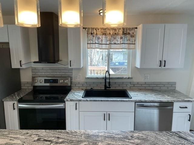 kitchen with ventilation hood, white cabinets, light stone counters, a sink, and stainless steel appliances