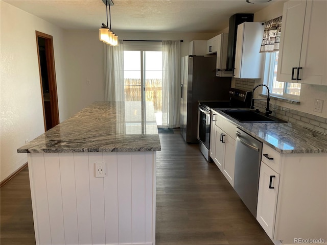 kitchen with plenty of natural light, dark wood-style flooring, a center island, and appliances with stainless steel finishes