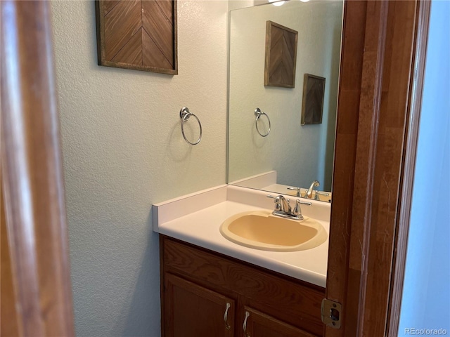 bathroom featuring vanity and a textured wall
