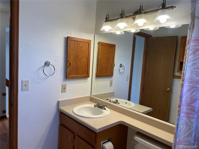 bathroom featuring vanity and a textured wall
