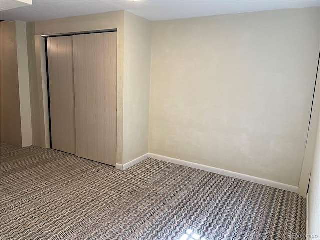 interior space featuring carpet flooring, a closet, and baseboards