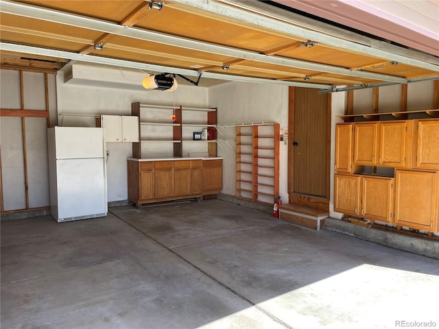 garage featuring freestanding refrigerator and a garage door opener