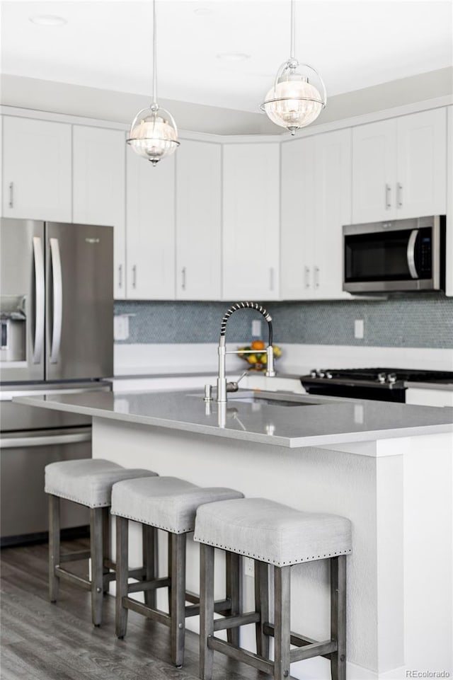 8917 Yates Dr, Westminster, CO 80031 - kitchen with appliances with stainless steel finishes, a sink, a breakfast bar, and tasteful backsplash