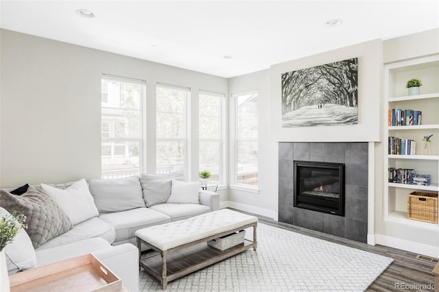 8917 Yates Dr, Westminster, CO 80031 - living area with wood finished floors, a fireplace, baseboards, built in shelves, and recessed lighting
