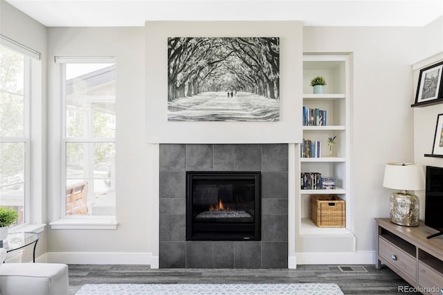 8917 Yates Dr, Westminster, CO 80031 - living area with dark wood-style floors, a fireplace, baseboards, and built in shelves
