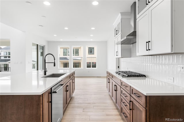8850 Moonshimmer Trl, Littleton, CO 80125 - kitchen with appliances with stainless steel finishes, wall chimney range hood, light wood-style floors, light countertops, and recessed lighting