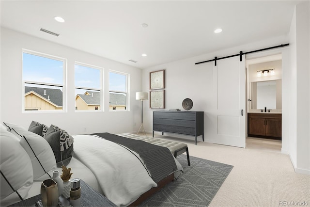 8850 Moonshimmer Trl, Littleton, CO 80125 - bedroom with a barn door, light colored carpet, recessed lighting, and ensuite bathroom
