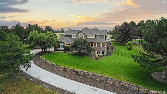 back house at dusk featuring a yard