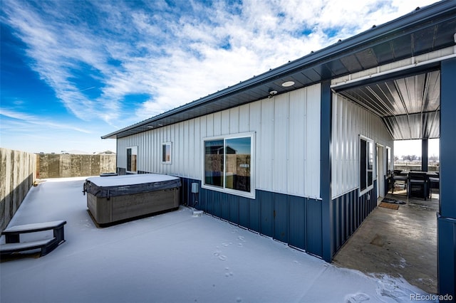 view of side of property featuring a hot tub and a patio