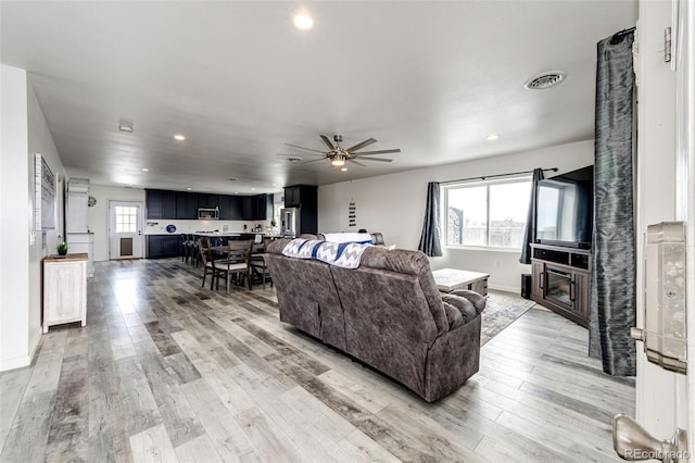 living room with wood-type flooring and ceiling fan