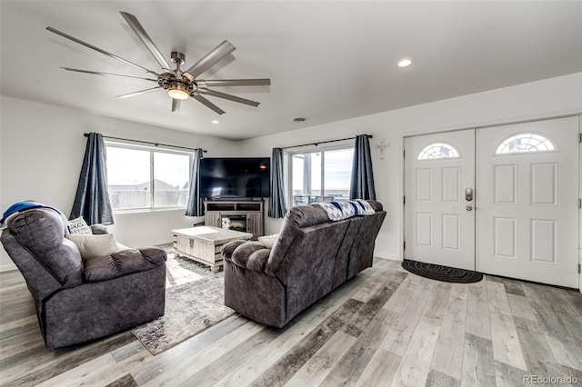 living room with ceiling fan, light hardwood / wood-style floors, and a healthy amount of sunlight