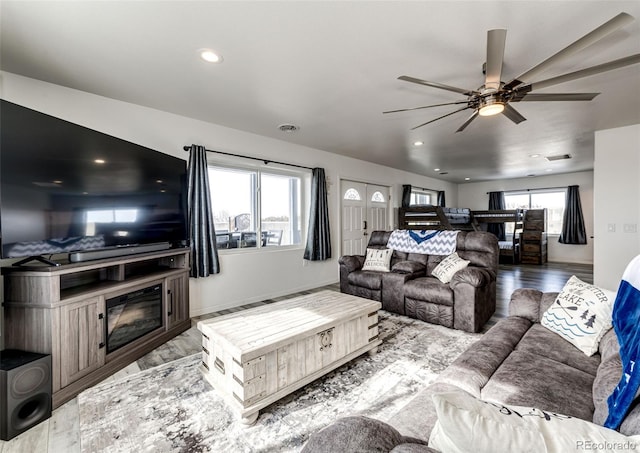 living room featuring ceiling fan and light hardwood / wood-style floors