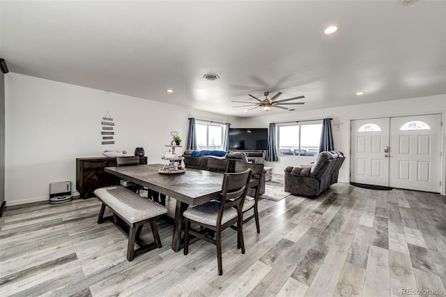 dining space with ceiling fan and light wood-type flooring