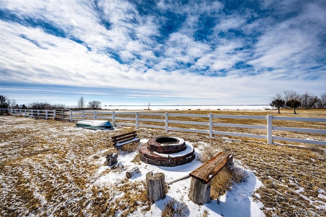 yard layered in snow featuring a rural view and an outdoor fire pit