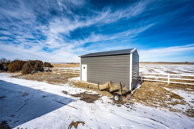 snow covered structure with a rural view