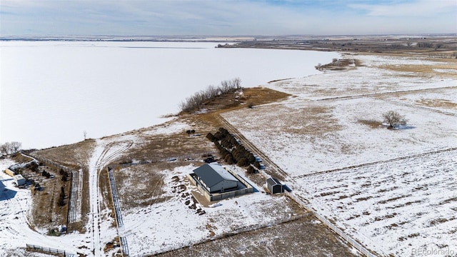 snowy aerial view with a water view