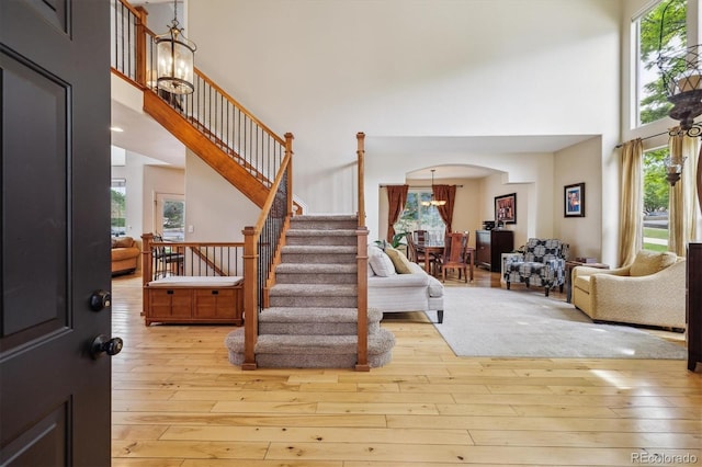 9478 Burgundy Cir, Highlands Ranch, CO 80126 - entrance foyer with a towering ceiling, a chandelier, arched walkways, stairway, and healthy amount of natural light