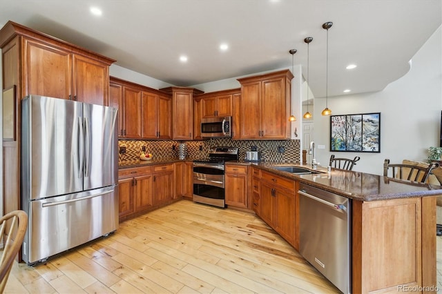 9478 Burgundy Cir, Highlands Ranch, CO 80126 - kitchen featuring appliances with stainless steel finishes, a peninsula, dark stone counters, light wood-style floors, and tasteful backsplash