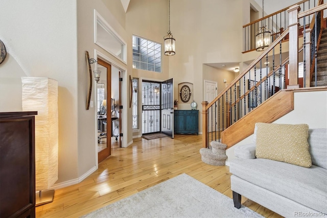 9478 Burgundy Cir, Highlands Ranch, CO 80126 - entryway featuring hardwood / wood-style floors, stairs, a chandelier, and a towering ceiling