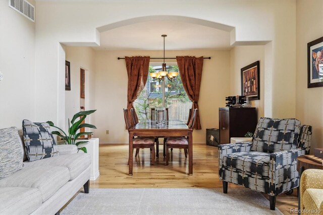 9478 Burgundy Cir, Highlands Ranch, CO 80126 - living area featuring a chandelier, arched walkways, and light wood-style flooring