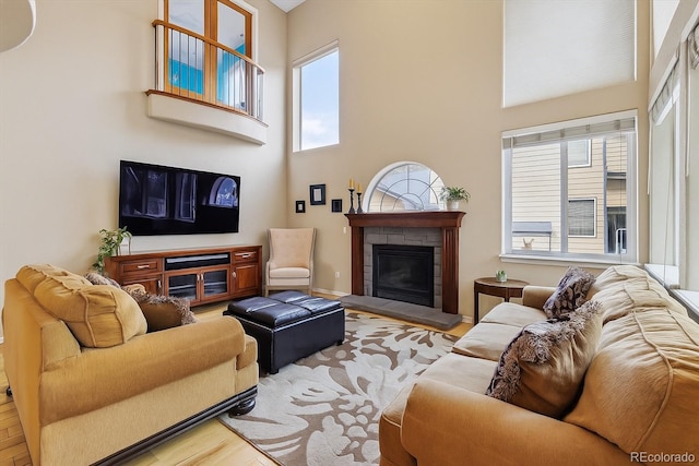 9478 Burgundy Cir, Highlands Ranch, CO 80126 - living room with a high ceiling, wood finished floors, and a tile fireplace