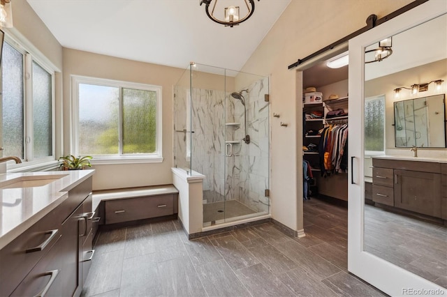 9478 Burgundy Cir, Highlands Ranch, CO 80126 - bathroom with two vanities, a marble finish shower, lofted ceiling, and a walk in closet