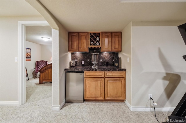 9478 Burgundy Cir, Highlands Ranch, CO 80126 - indoor wet bar featuring light colored carpet, backsplash, arched walkways, and a textured ceiling