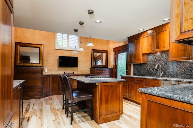2409 E Cedar Ave, Denver, CO 80209 - kitchen featuring light wood-type flooring, dark stone countertops, a center island, decorative backsplash, and recessed lighting