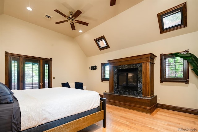 2409 E Cedar Ave, Denver, CO 80209 - bedroom featuring vaulted ceiling, light wood-style floors, a fireplace, ceiling fan, and recessed lighting