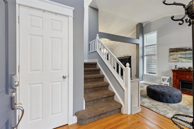 stairway featuring wood-type flooring and vaulted ceiling