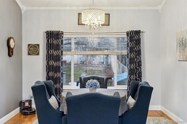 dining space featuring an inviting chandelier, ornamental molding, wood-type flooring, and a wealth of natural light