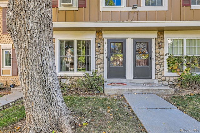 entrance to property featuring stone siding and board and batten siding