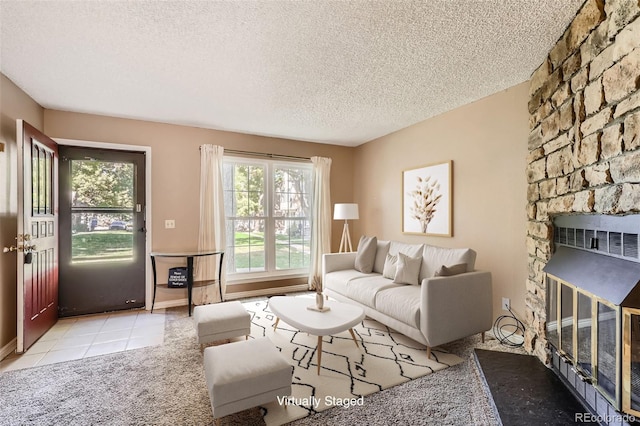 tiled living room featuring a fireplace and a textured ceiling