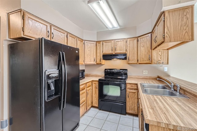 kitchen featuring light brown cabinetry, sink, light tile patterned floors, and black appliances