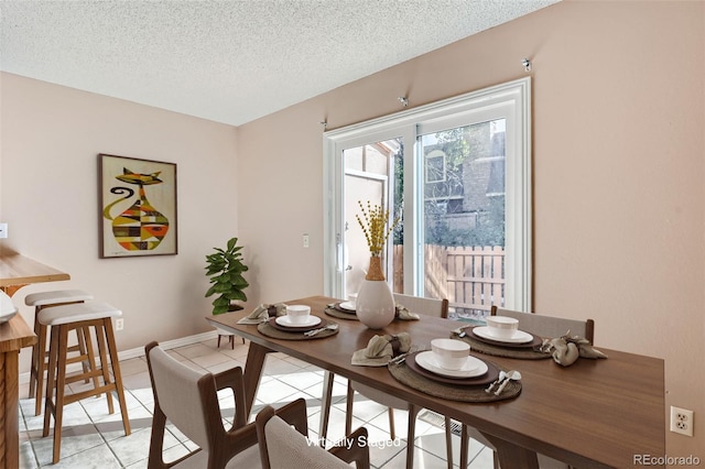 dining area with light tile patterned floors and a textured ceiling