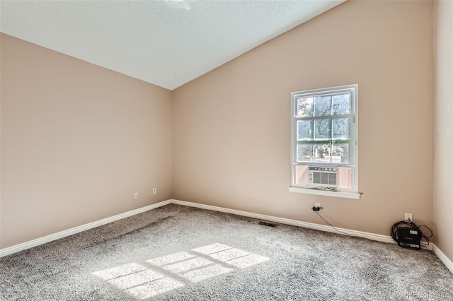 carpeted spare room with lofted ceiling and cooling unit