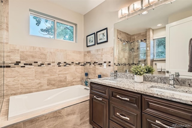 1916 S Elati St, Denver, CO 80223 - full bath featuring a bath, double vanity, a shower stall, and tile walls